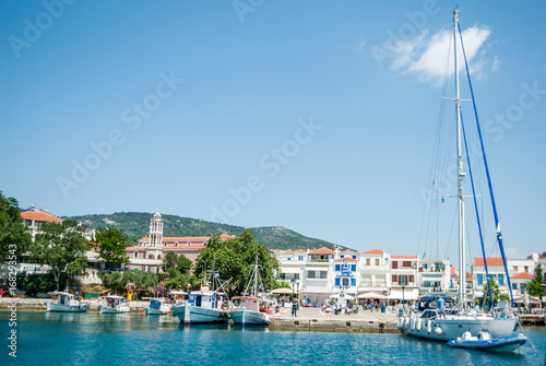 Boats big and small parked in the harbor, overlooking the city of Skiathos, Greece