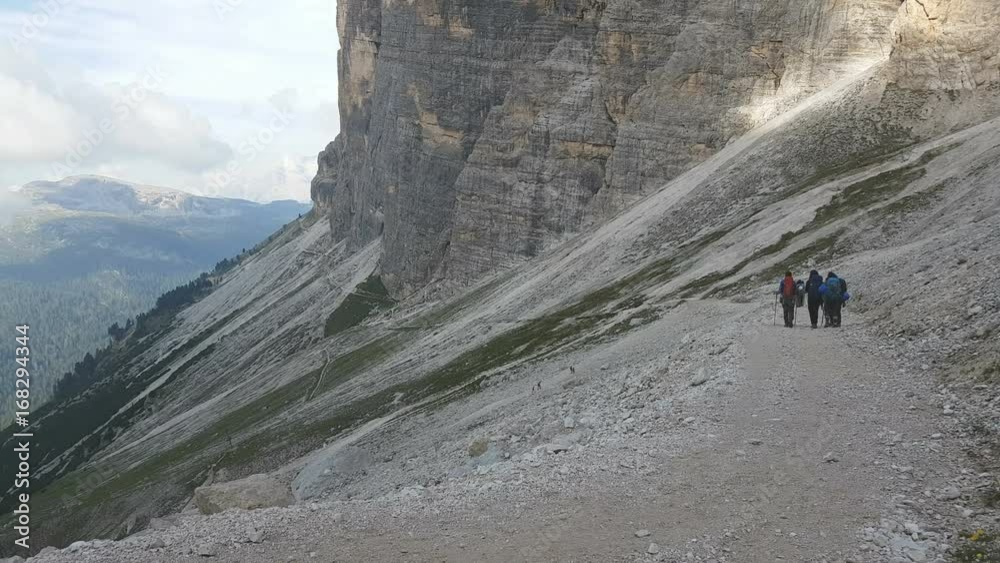 Mountaineers descending along path after climbing in dolomites Mountaineers descending along path after climbing in dolomites