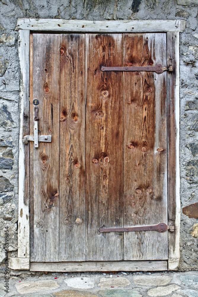 Old wooden door with grey field stone wall