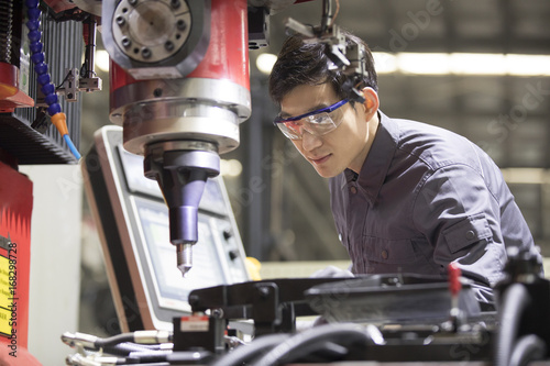 Confident engineer working in the factory