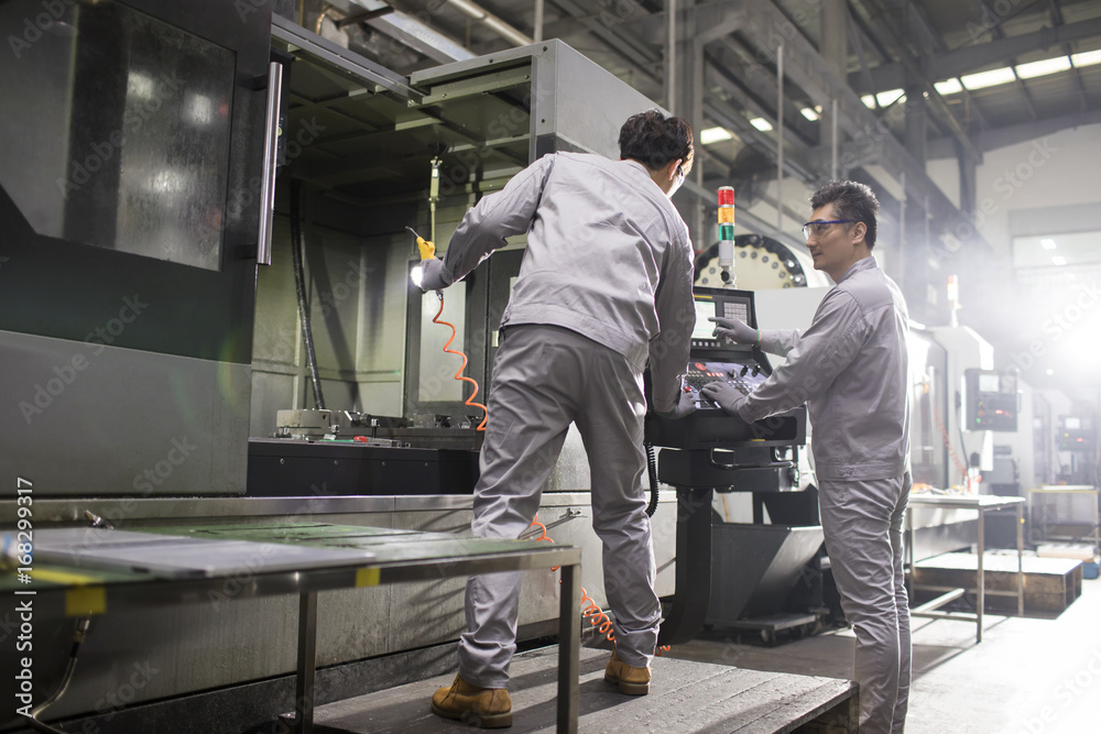 Confident engineers working in the factory