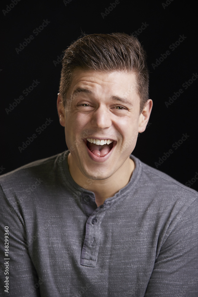 Laughing young white man looks to camera, vertical portrait Laughing young white man looks to camera, vertical portrait