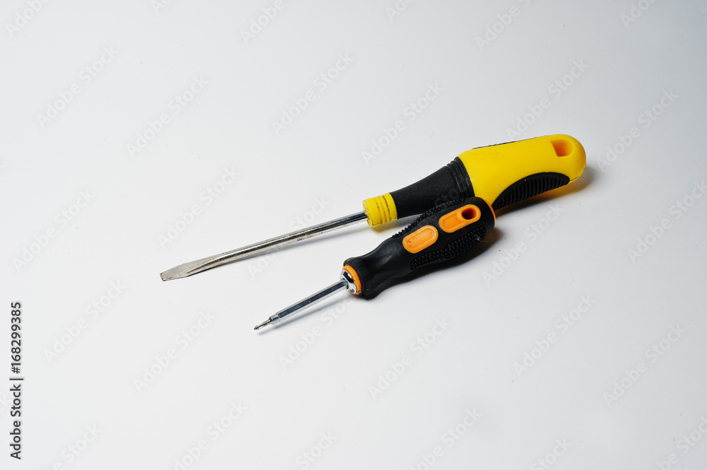 Close-up photo of black and yellow screwdrivers on the white background. Close-up photo of black and yellow screwdrivers on the white background.