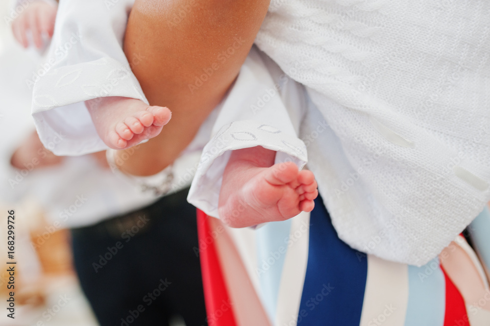 Obraz premium Close-up photo of small legs of a newborn baby on mother's hands.