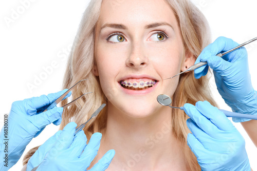 Hands holding dentist tools near woman
