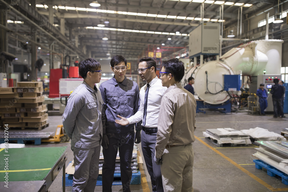 Businessman and engineers talking in the factory Businessman and engineers talking in the factory