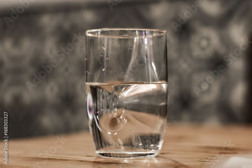Modern glass of water sitting on a table with blured background