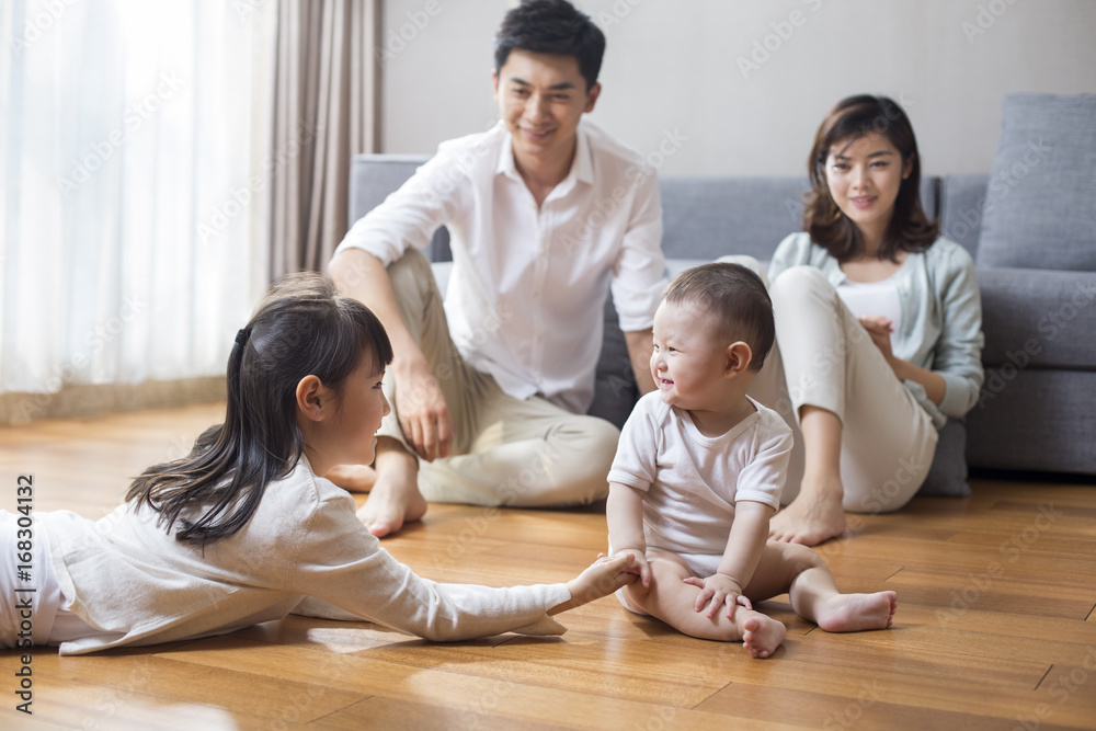 Happy young family sitting together in the living room Happy young family sitting together in the living room