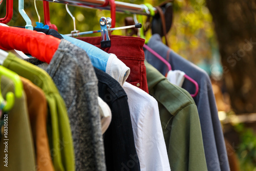 Hangers with men's and women's clothing at the garage sale