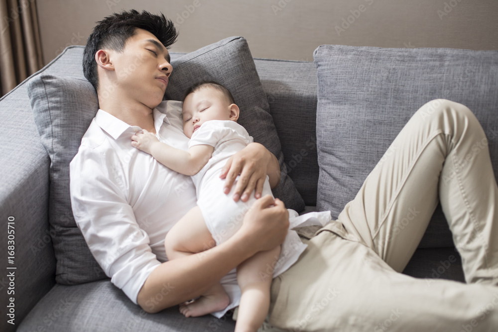 Young father and baby boy sleeping on sofa Young father and baby boy sleeping on sofa