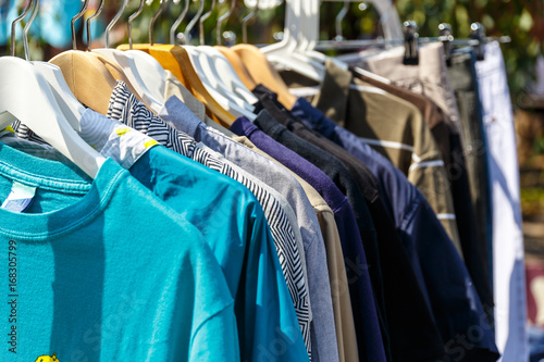 Hangers with men's and women's clothing at the garage sale