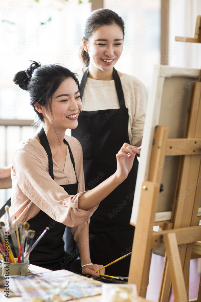 Young women painting in studio