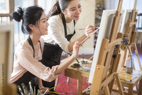 Young women learning painting in art class