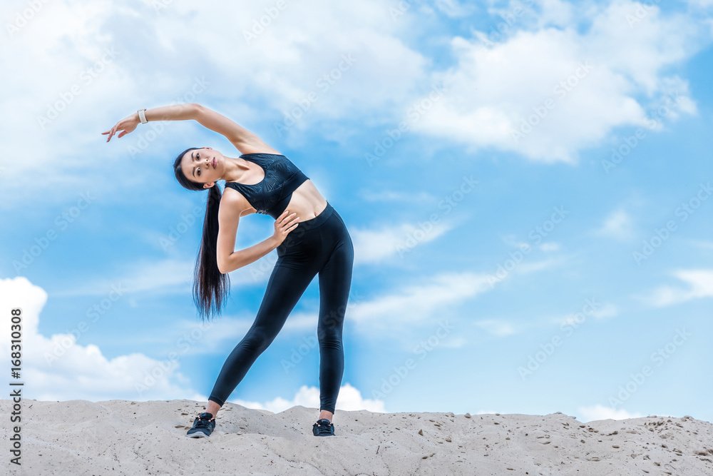 sportswoman stretching against sky sportswoman stretching against sky