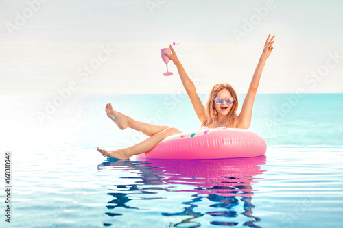 Summer Vacation. Woman in bikini on the inflatable donut mattress in the SPA swimming pool.