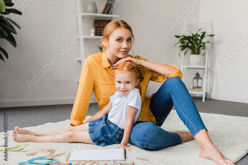 mother and daughter sitting on floor