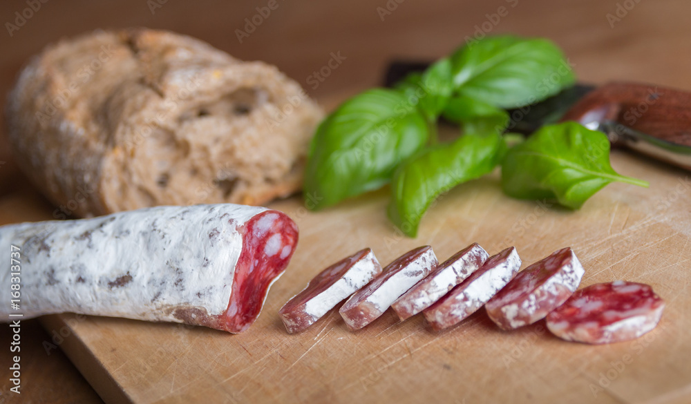 italian salami with herbs on a cutting board italian salami with herbs on a cutting board