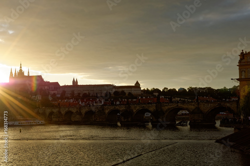 Czech Republic, Prague. Hradcany Castle. Sunset view with Sun rays scattered in front of the castle, outline and shadow of castle.