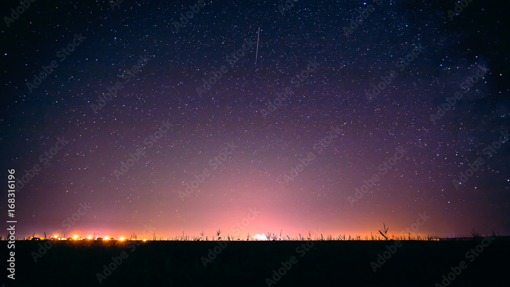 Colorful Night Starry Sky Above The Yellow City Lights. Night Glowing Stars