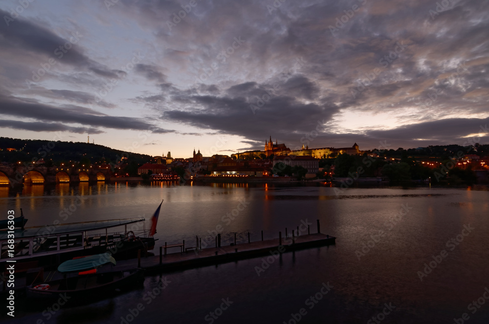 Czech Republic, Prague, Night view on Hradcany castle and Charles Bridge. Vltava in the foreground.