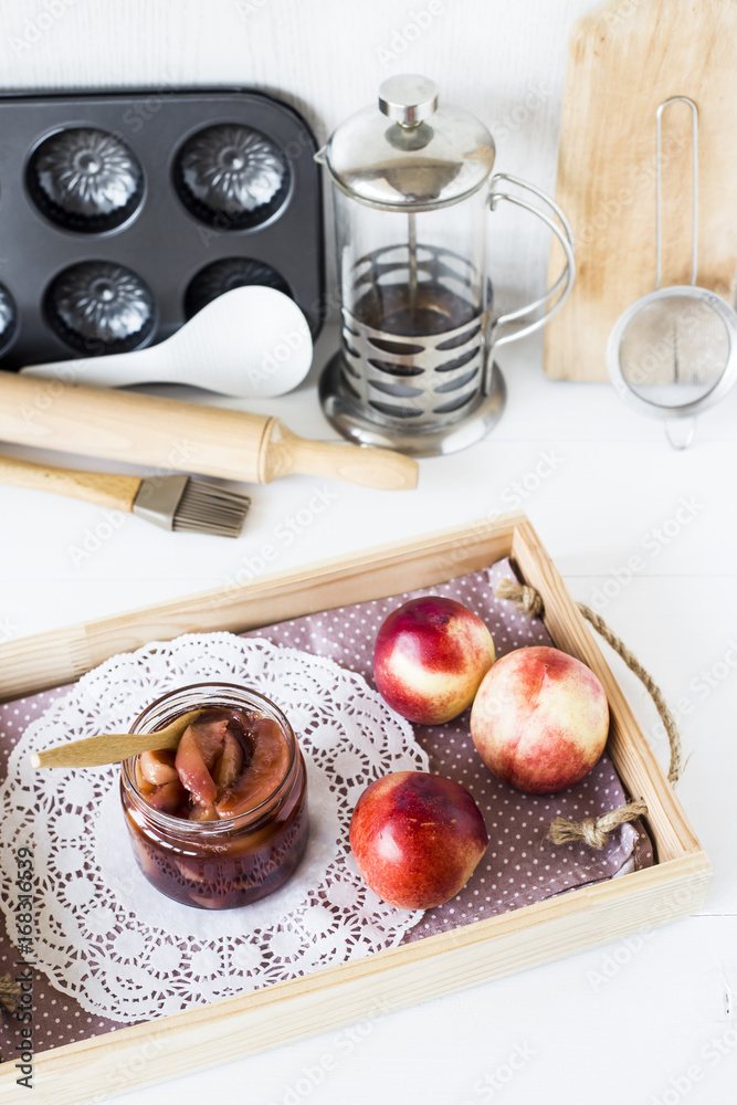 Nectarine jam in a jar next to fresh fruits
