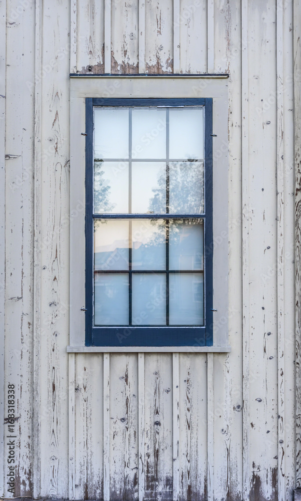 blue window on side of old faded white barn blue window on side of old faded white barn