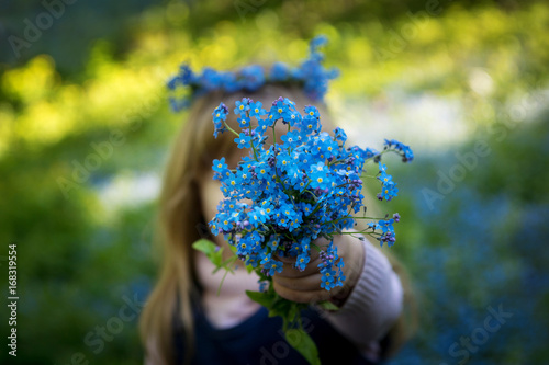 the little girl stretches out ahead a bouquet of forget-me-nots