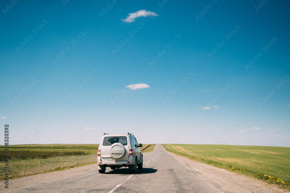 Gray SUV Car rides along Road In Spring Summer Fields Landscape