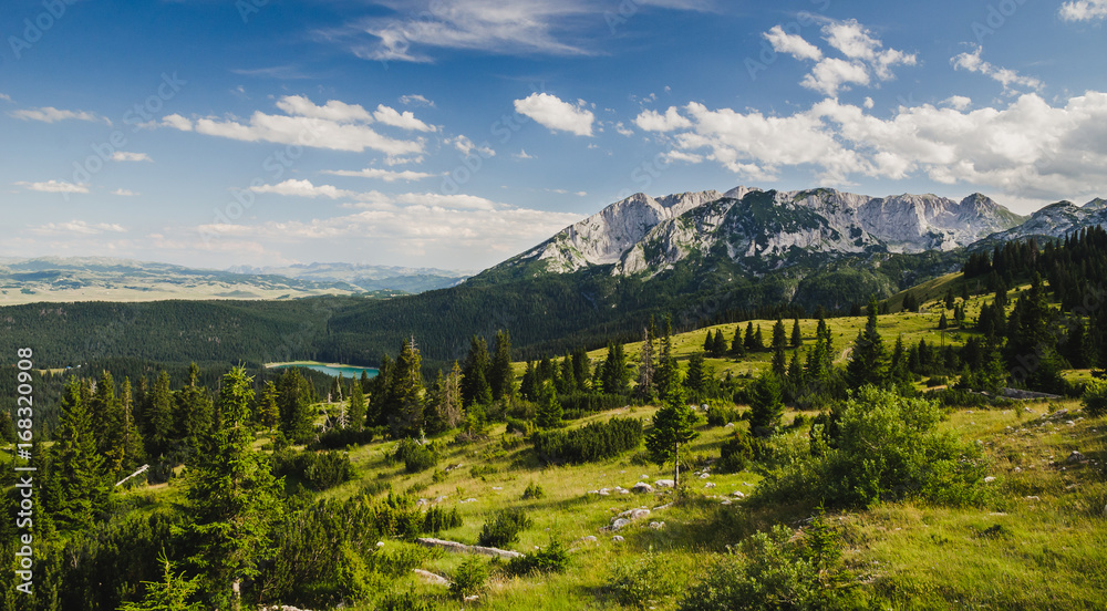 View on a distant mountain and a lake in the forest. Black lake at mountain Durmitor, Montenegro.