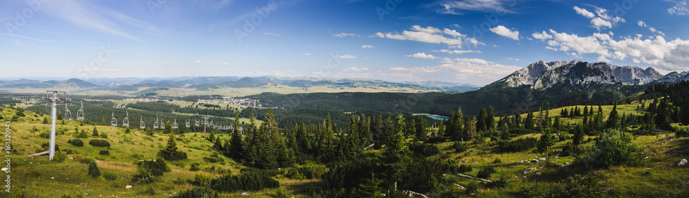 View on a distant mountain and a lake in the forest. Black lake at mountain Durmitor, Montenegro. Panorama.