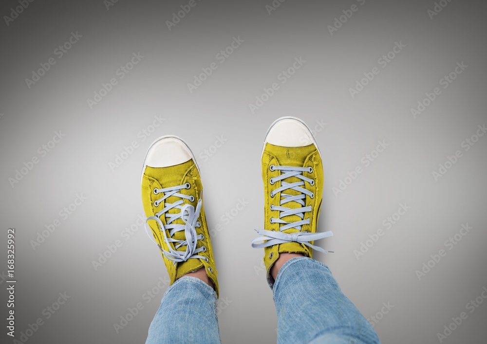 Yellow shoes on feet with grey background Yellow shoes on feet with grey background