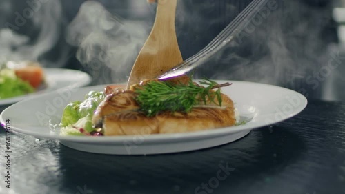 Close-up Serving Fish on a Plate Decorated with Vegetables and Salat