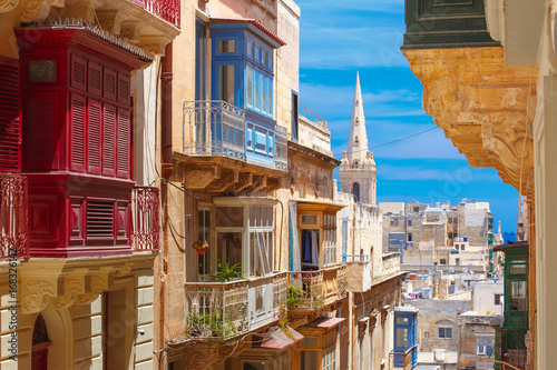 The traditional Maltese colorful wooden balconies and St. Paul's Anglican Pro-Cathedral in Valletta, Malta