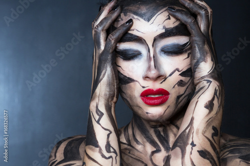 Женщина с разрисованным телом и лицом испытывает эмоцию стресса.