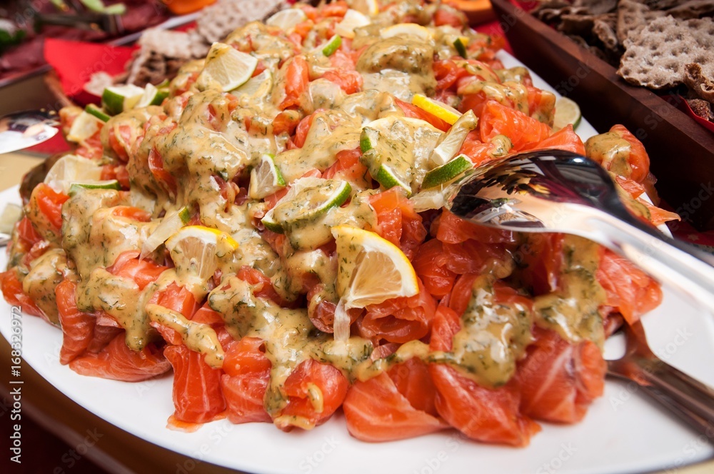 Fresh salmon salad served on a wide plate on a table Fresh salmon salad served on a wide plate on a table