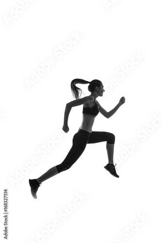 Fototapeta Naklejka Na Ścianę i Meble -  Black silhouette of a girl in sportswear jumping against a white background, studio