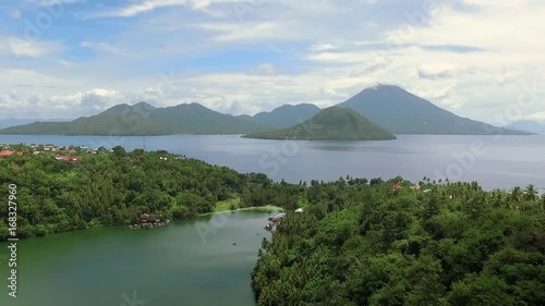 Aerial view of tropical Laguna Lake Tidore and volcano island in Ternate, Indonesia. Shot with drone on sunny day with blue sky in Indonesia, fly forward photo