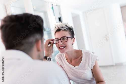 Male optometrist checking patient's vision at eye clinic.