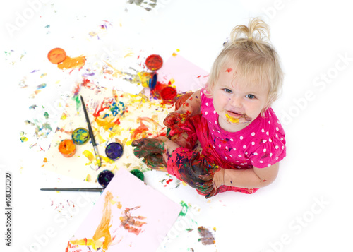Creative baby girl with finger paints. Messy play for infants and toddlers. 