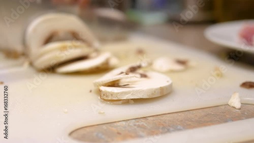 Chopping mushrooms with knife on chopping board