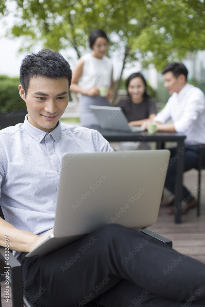 Young businessman using laptop outdoors Young businessman using laptop outdoors