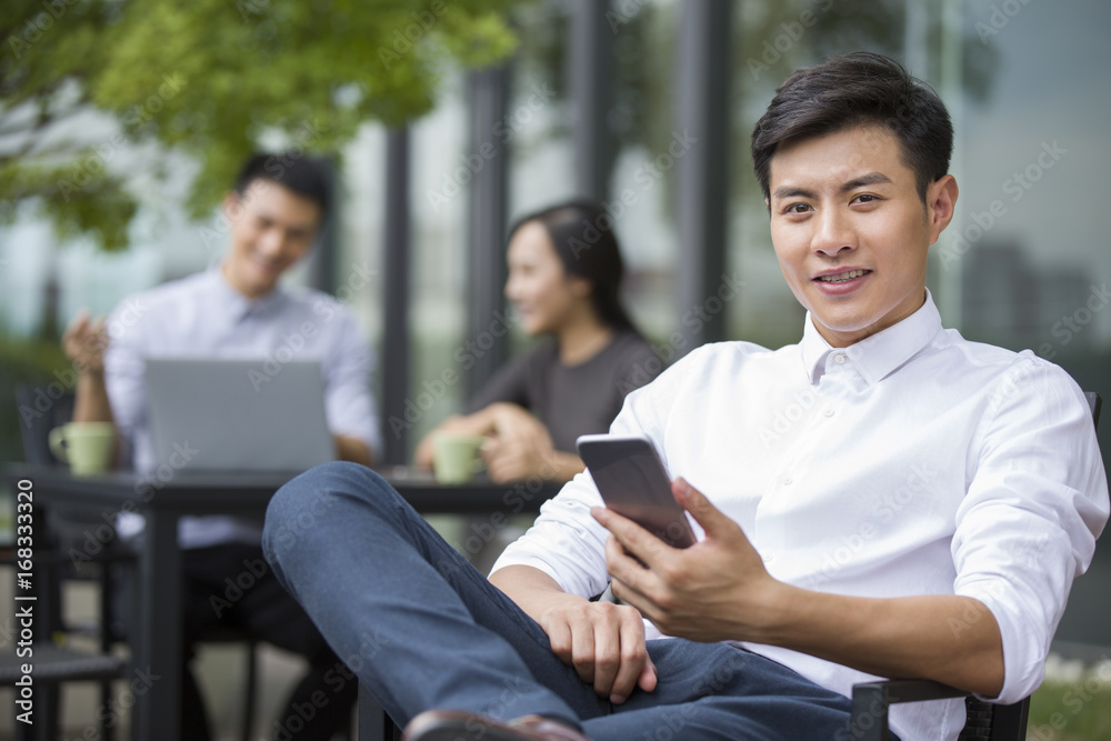 Young businessman holding a smart phone outdoors Young businessman holding a smart phone outdoors