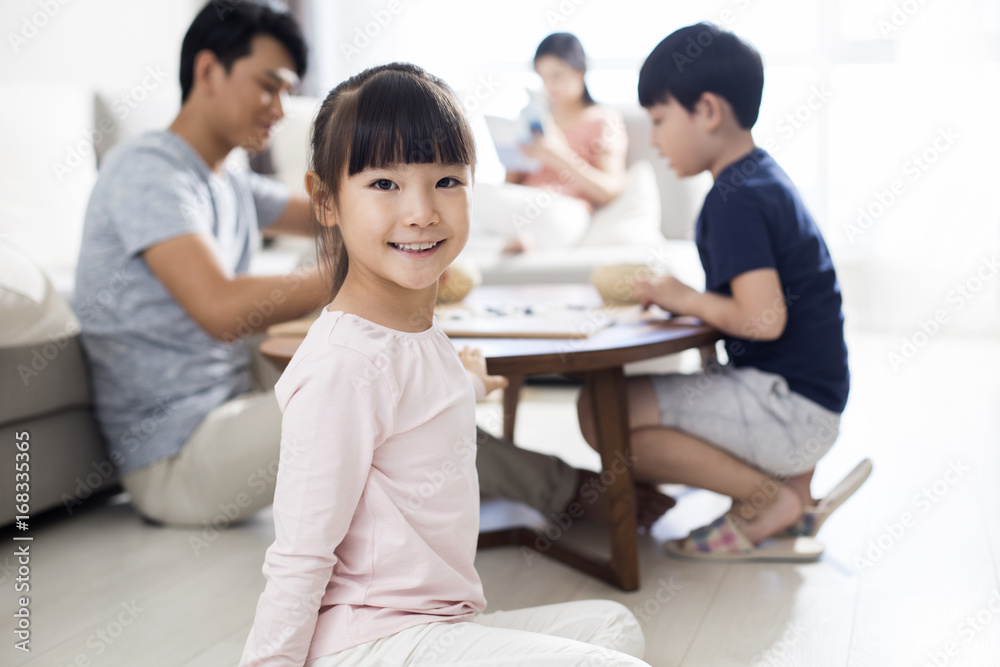 Portrait of cute smiling girl with family sitting in background Portrait of cute smiling girl with family sitting in background