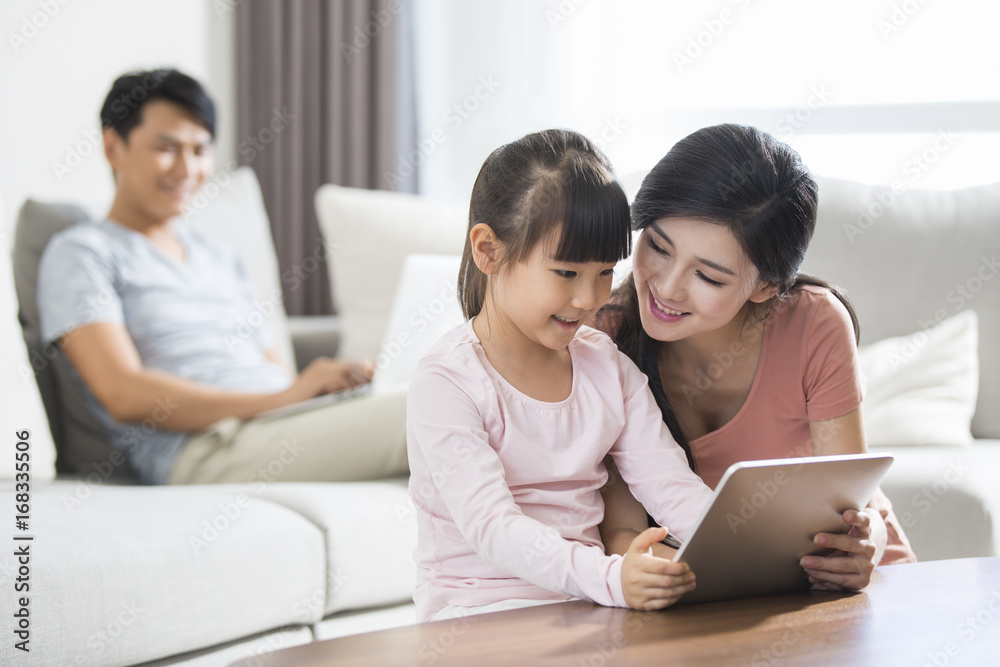 Happy young family using digital gadgets at home Happy young family using digital gadgets at home