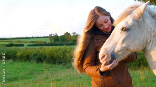young woman and her horse at sunset in a field