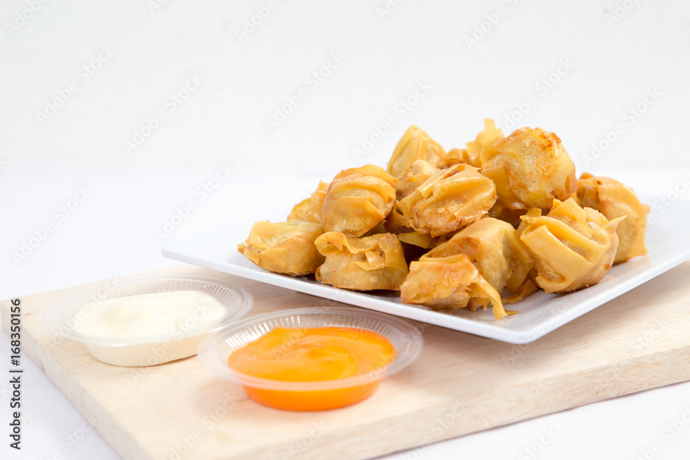 Deep fried wonton or fried dumplings cuisine on white plate Deep fried wonton or fried dumplings cuisine on white plate
