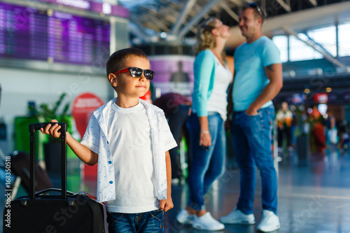 Cute little boy with suitcase at airport photo