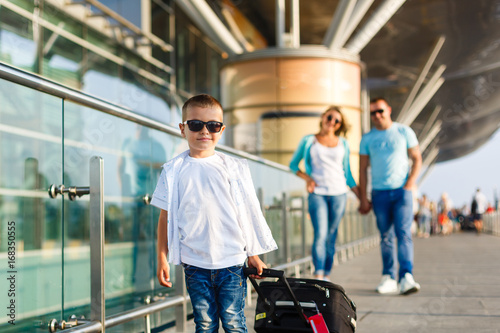 Cute little boy with suitcase at airport photo