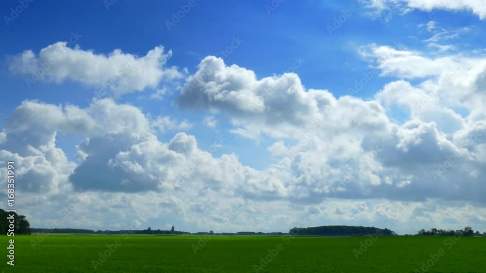Billowy clouds drift over lush green rural landscape.
Billowy clouds drift over lush green rural landscape.