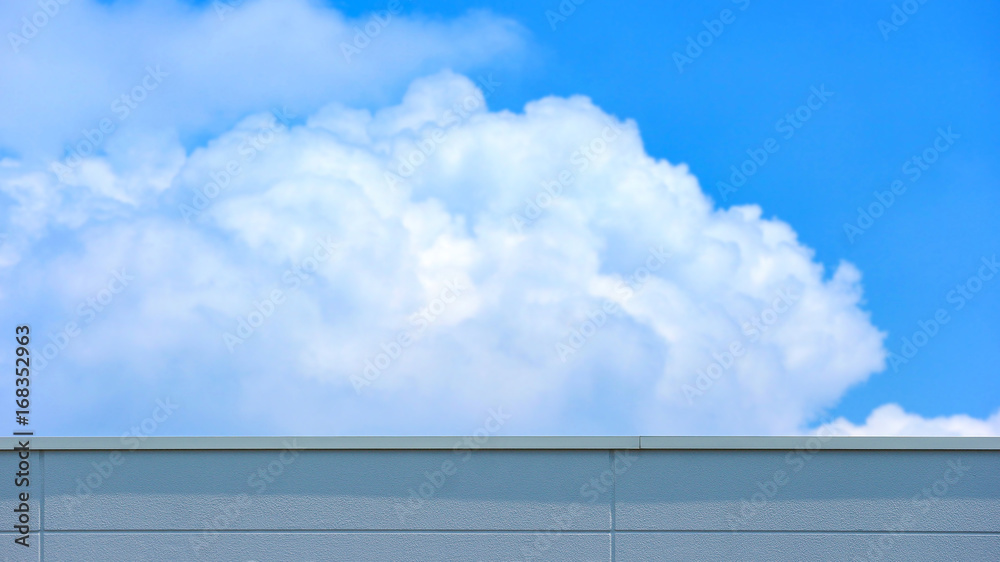 concrete wall of high building with blurred cloud and blue sky as background concrete wall of high building with blurred cloud and blue sky as background